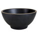A black melamine bowl with a gold rim.