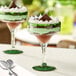 Two Acopa margarita glasses filled with green and chocolate dessert on a table.