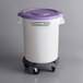 A Baker's Mark white round mobile ingredient storage bin with a purple allergen-free lid on a gray dolly.