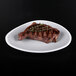 A piece of steak on an Elite Global Solutions gray speckle triangle melamine plate.