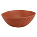 A brown melamine bowl with specks on a slanted surface.