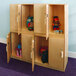 A Whitney Brothers wooden storage cabinet with toys inside.