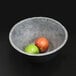 An Elite Global Solutions Basalt melamine serving bowl with two apples in it.