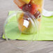 A plastic cup with a Fabri-Kal clear plastic dome lid with fruit inside.