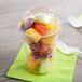 A clear plastic cup of fruit with a Fabri-Kal clear plastic dome lid.