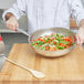 A chef using a Vollrath Centurion fry pan to cook vegetables.