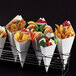 A rack of white paper food cones filled with food.