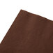 A Hoffmaster chocolate brown paper napkin with a hole in it.