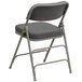 A gray Flash Furniture metal folding chair with a gray cushion.