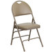 A beige metal folding chair with a padded tan cushion and easy-carry handle.