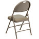 A Flash Furniture beige metal folding chair with a padded tan seat.