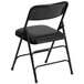A Flash Furniture black metal folding chair with a black padded seat.