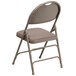 A Flash Furniture beige metal folding chair with a padded seat.