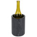 A wine bottle in a black marbled container.