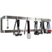 An Advance Tabco stainless steel wall mounted pot rack with many double prong hooks holding kitchen utensils.