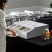 An Avantco refrigerated countertop prep rail on a hotel buffet counter with food in white plates.