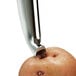 A close-up of a potato being peeled with an OXO straight stainless steel blade peeler.