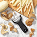 An OXO Good Grips black "Y" vegetable peeler on a wooden cutting board with a potato.