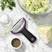 An OXO black and purple "Y" vegetable peeler with a wide straight stainless steel blade and a bowl of cabbage.
