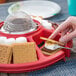 A hand holding a Sterno S'mores on a red tray.