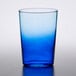 An Arcoroc blue beverage glass with a white rim on a table.