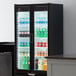 A Beverage-Air black glass door refrigerator full of drinks with LED lighting.