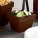 A group of brown Tablecraft square condiment bowls with cucumbers in them.