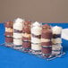 A row of GET Reusable Plastic Dessert Shot Glasses filled with chocolate and peanut butter desserts.