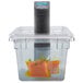 A Breville sous vide immersion circulator head in a container with salmon and dill.
