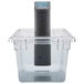 A clear plastic container with a Breville sous vide circulator inside.