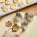 A person using an Ateco stainless steel fruit shaped cookie cutter.