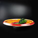 A Elite Global Solutions round melamine platter with a green pepper on it.