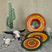 A table set with colorful melamine plates including a multi-color round platter with a green center.