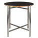 A Bon Chef round table top with a black finish on a metal base.