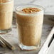 A glass of milkshake with DaVinci Gourmet Peanut Butter syrup and nuts.