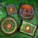 A group of three green and brown Elite Global Solutions Earth Elements square melamine plates with spiral designs on a table outdoors.