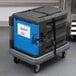 A black Metro Mightylite food pan carrier with a blue door on a cart.