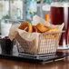 A chrome square mini fry basket filled with fried onion rings.