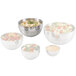 A set of four Vollrath stainless steel bowls with salad and vegetables on a white background.