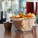 An Acopa chrome square mini fry basket filled with french fries on a table.