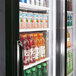 A Turbo Air black refrigerated merchandiser with drinks inside.