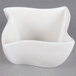 An American Metalcraft Squavy white porcelain ramekin with a curved edge on a gray background.