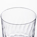 A close up of a Fineline clear plastic wine cup with a wavy pattern.