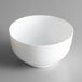 An Arcoroc white opal glass salad bowl on a gray surface.