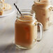 Two glass mugs filled with coffee and DaVinci Gourmet Sugar Free French Vanilla Flavoring Syrup with a straw in one.