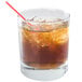 An Arcoroc Islande rocks glass of brown liquid with ice and a straw.