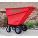 A red Magliner motorized hopper cart on a sidewalk.