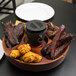 A Town wooden Pu Pu platter with food on it.