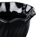 A black Cambro plastic bowl with wavy edges.