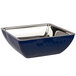 A Bon Chef cobalt blue square bowl with silver accents on a counter in a salad bar.